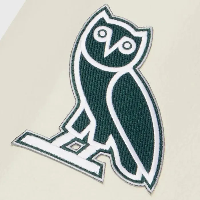Green and white owl logo patch on a beige background