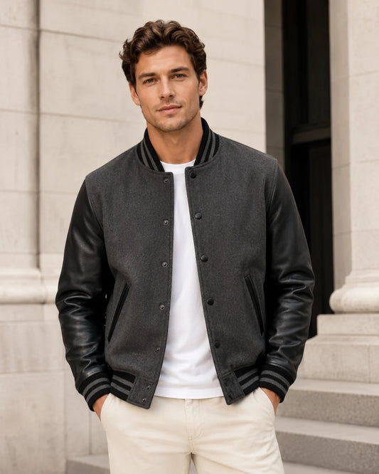 Male model wearing a blank men's black and grey varsity jacket with black leather sleeves