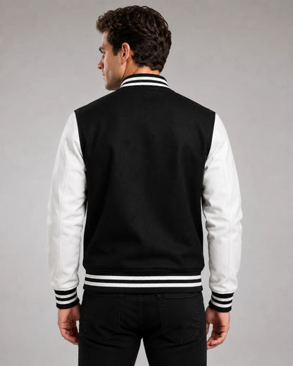 Back view of mens black and white varsity jacket with blank black wool body, white leather sleeves, and striped ribbed hem on male model