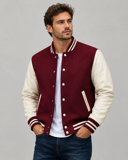 Mens burgundy varsity jacket with wool body, cream leather sleeves, snap buttons, and striped ribbed trim worn by male model
