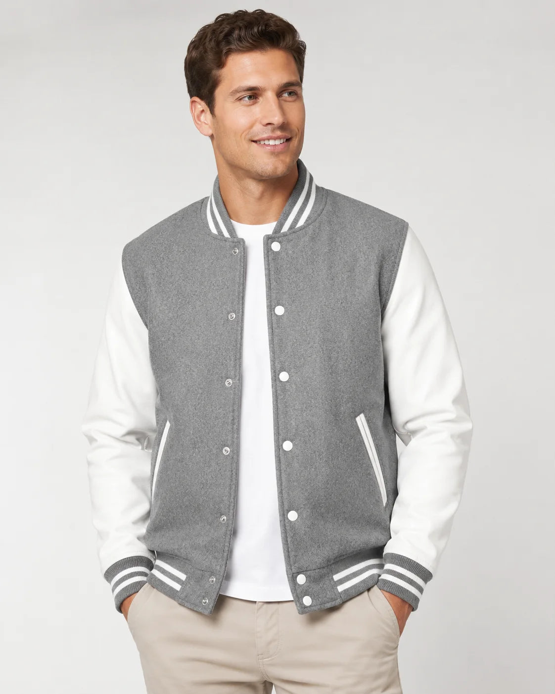 Mens grey varsity jacket with wool body, white leather sleeves, snap buttons, and striped ribbed trim worn by male model