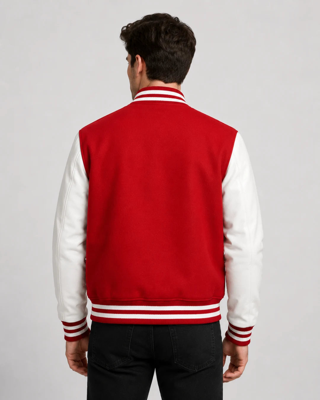 Back view of mens red varsity jacket with blank wool body, white leather sleeves, and striped ribbed hem on male model