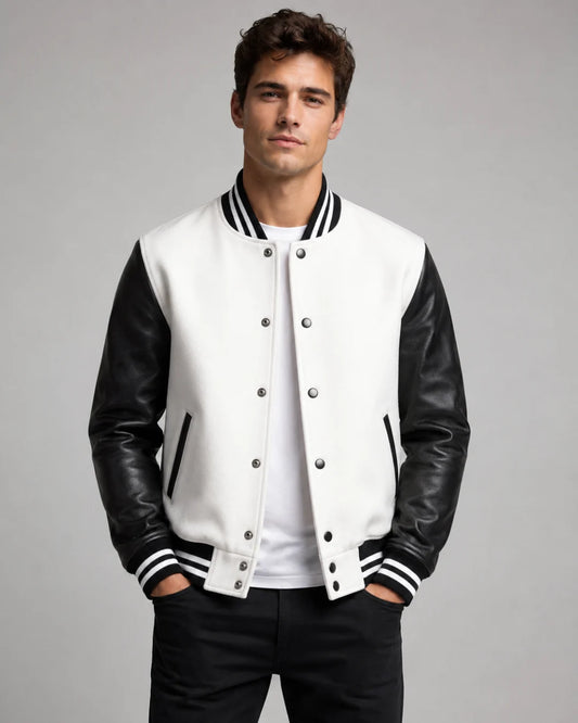 Mens white and black varsity jacket with wool body, black leather sleeves, snap buttons, and striped ribbed trim worn by male model