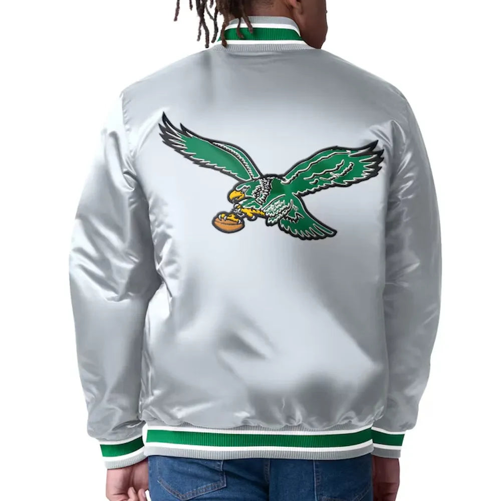 White jacket with green eagle logo on the back, worn by a person.