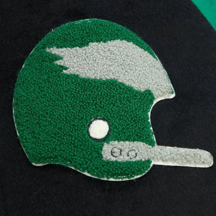 Green and white football helmet patch on a black background