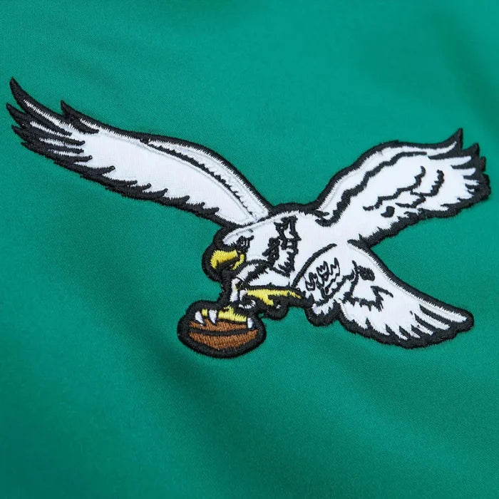 Embroidered eagle holding a football on a green background
