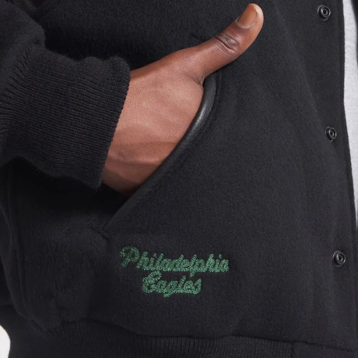 Black varsity jacket with 'Philadelphia Eagles' embroidery on a pocket.