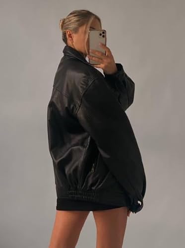 Person wearing a black jacket and shorts against a plain background